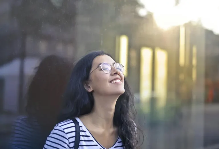 Pessoa sorrindo usando óculos inteligentes em ambiente urbano