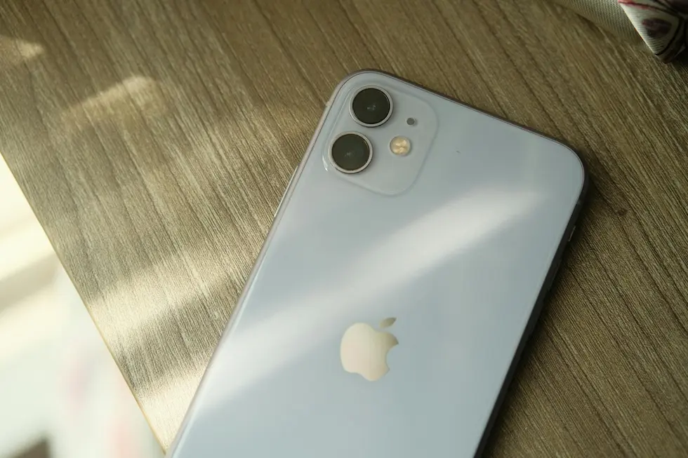 iPhone 16e em destaque sobre mesa de madeira clara