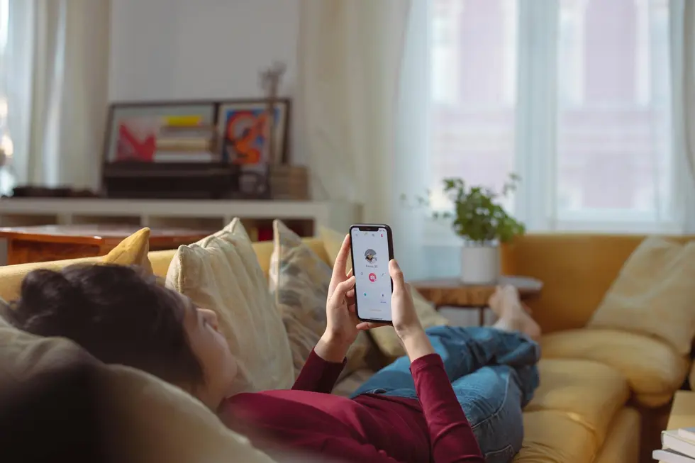 Pessoa usando smartphone com novo visual do app Gemini em home office
