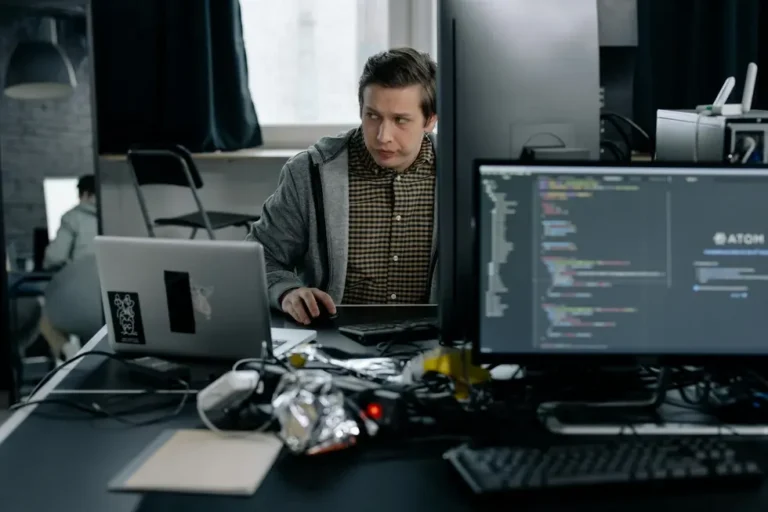 Equipe trabalhando enquanto segurança digital emite alerta no monitor