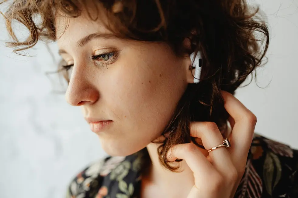 Pessoa usando AirPods no ônibus ao amanhecer