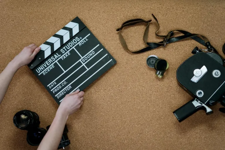 Mesa com passes de festival, celular exibindo streaming e pipoca para sessão Cannes