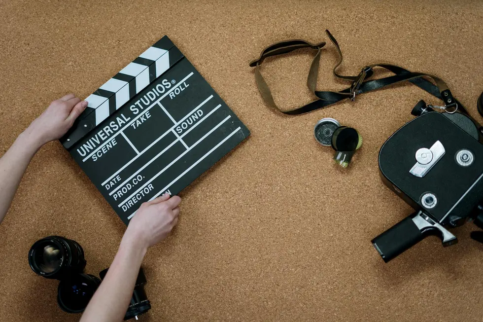 Mesa com passes de festival, celular exibindo streaming e pipoca para sessão Cannes