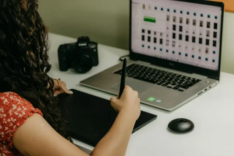 Pessoa jovem com laptop, certificados de cursos e gadgets novos na mesa