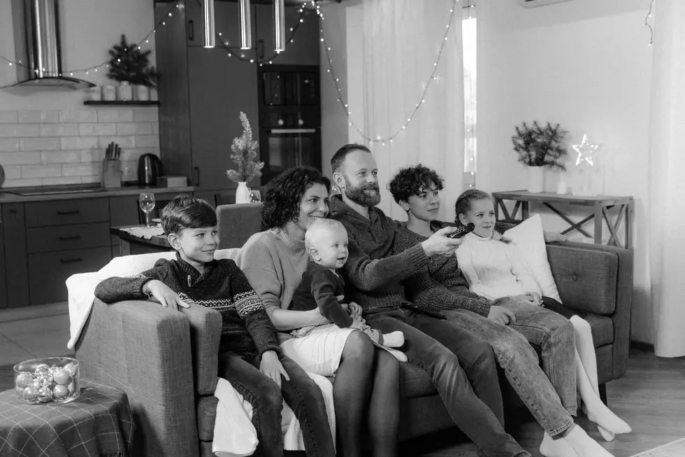 Família brasileira feliz reunida em torno do celular assistindo TV