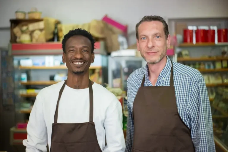 Proprietários felizes utilizando aplicativo de estoque no comércio