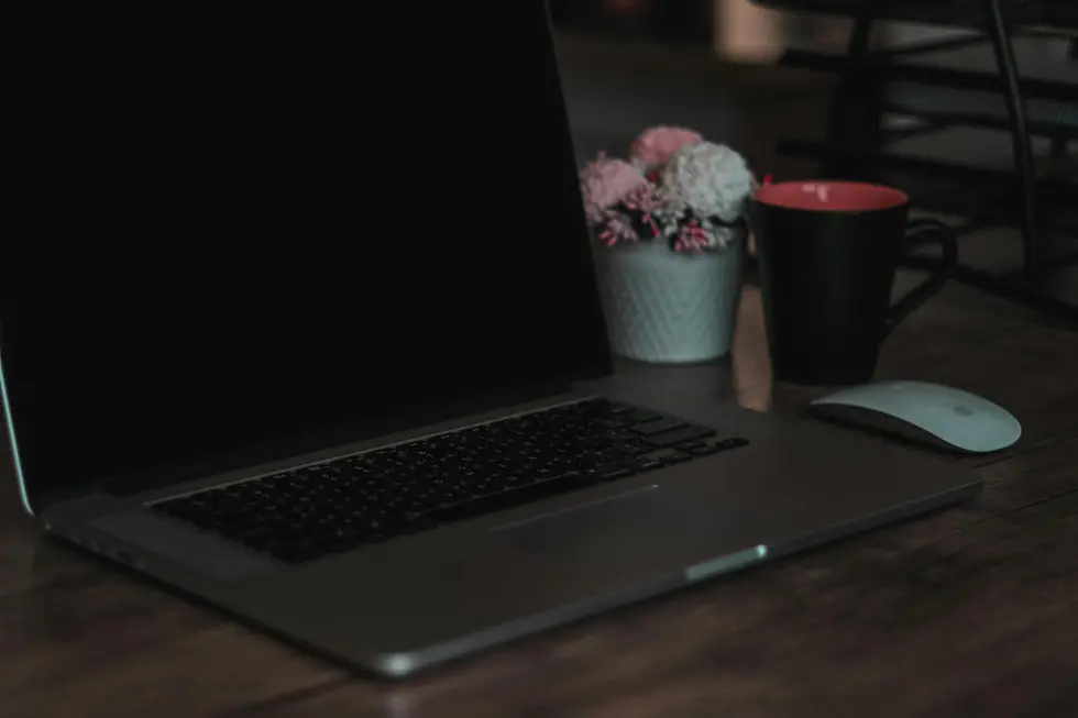 Mouse moderno ao lado de notebook e apoio ergonômico na mesa de home office