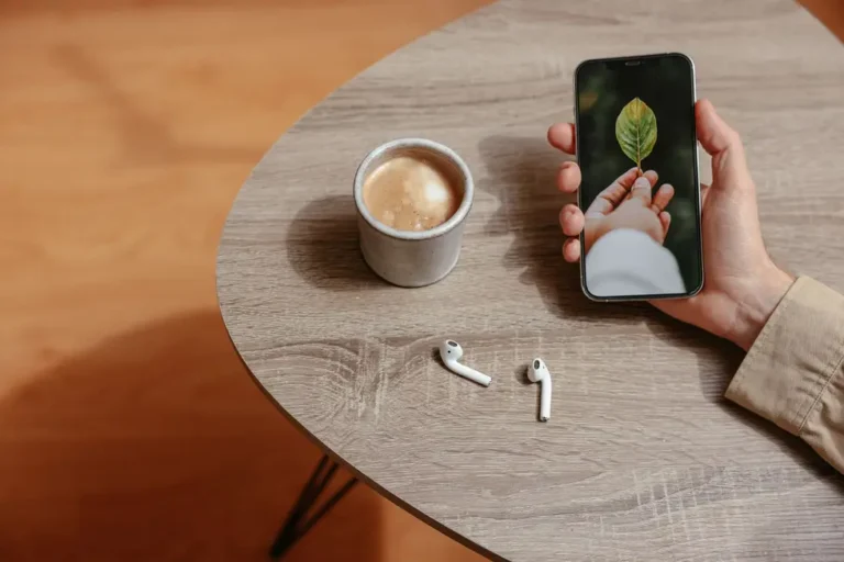 Usuário segurando Enco Buds3 próximo ao celular