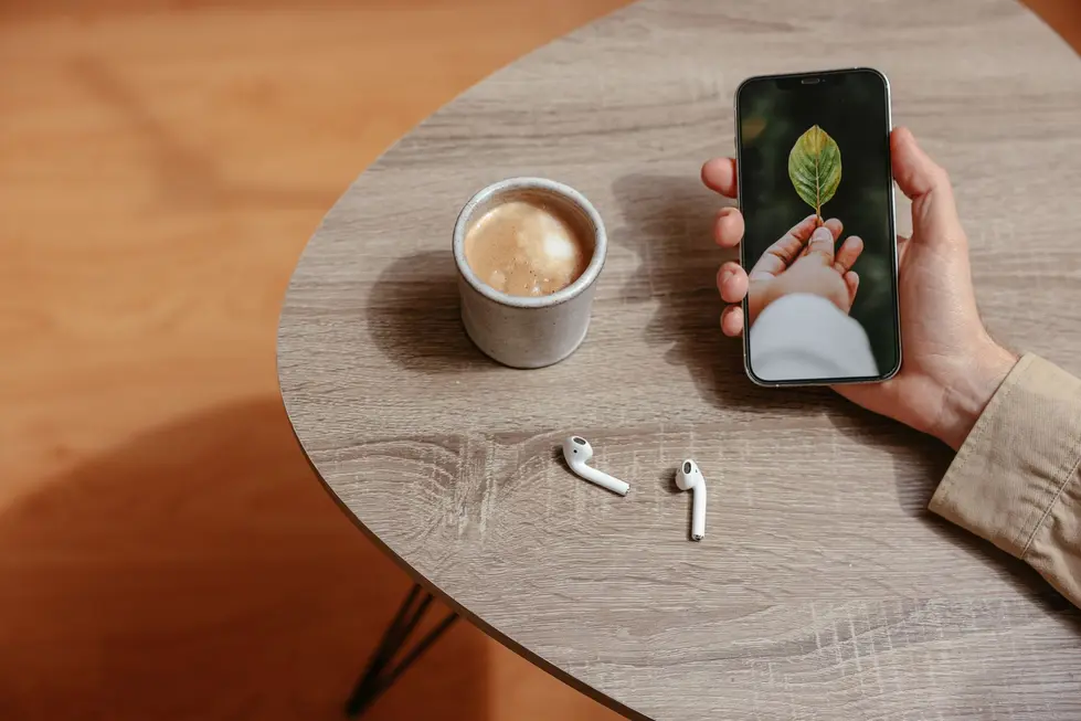 Usuário segurando Enco Buds3 próximo ao celular