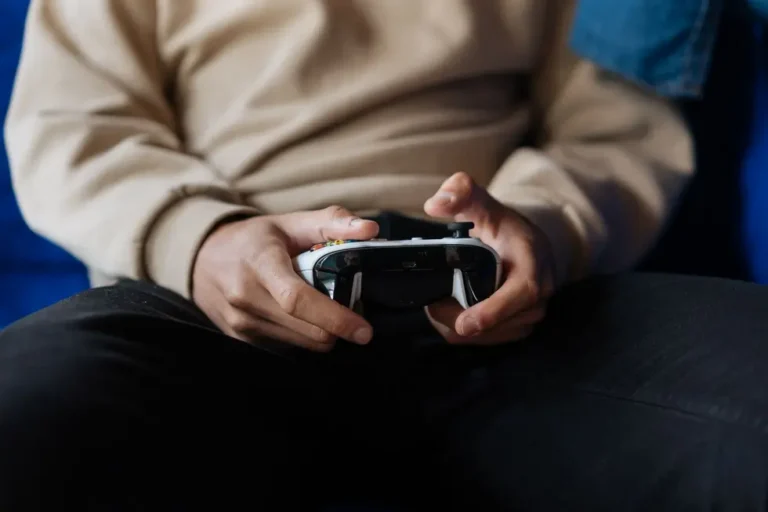 Mãos adultas segurando controle Xbox com Game Pass ativo na TV