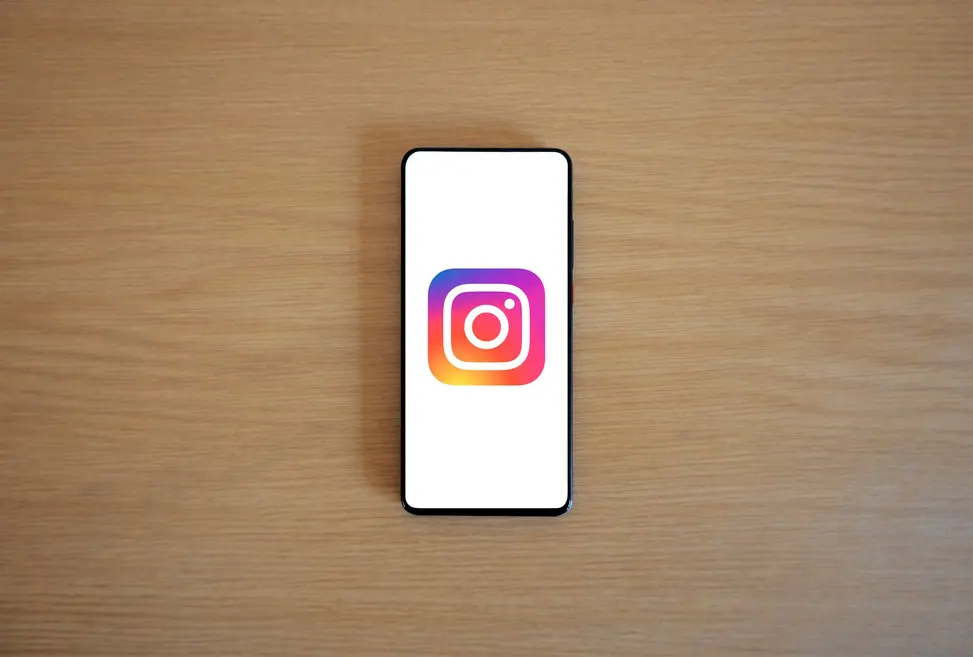 Smartphone exibindo recursos avançados do Instagram entre acessórios coloridos