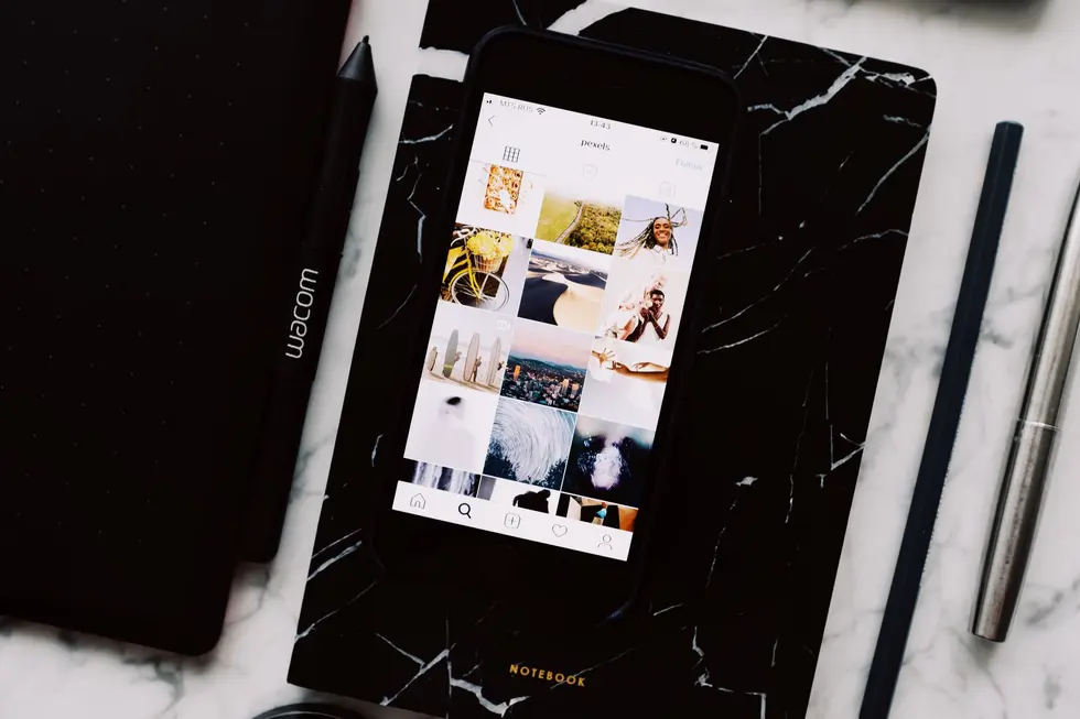 Celular sobre mesa mostrando menu de privacidade do Instagram