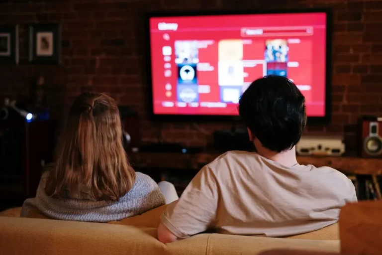 Grupo de amigos assistindo Netflix em sala moderna com ambiente aconchegante