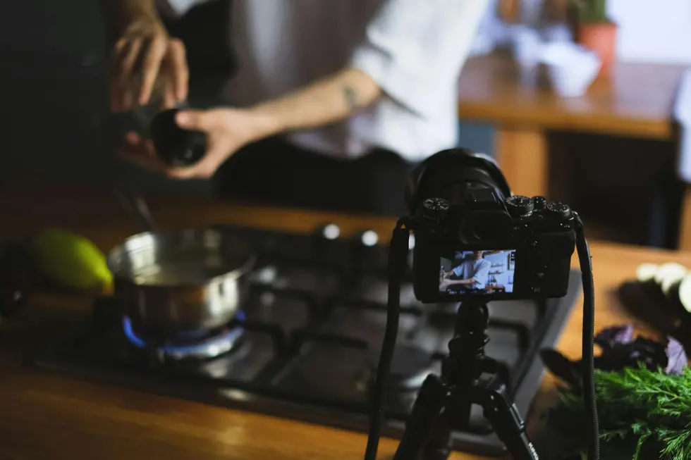 Cozinha moderna com ingredientes frescos e tela exibindo chef Michelin