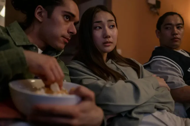 Jovens adultos curtindo filme de sequência em TV grande com som de qualidade