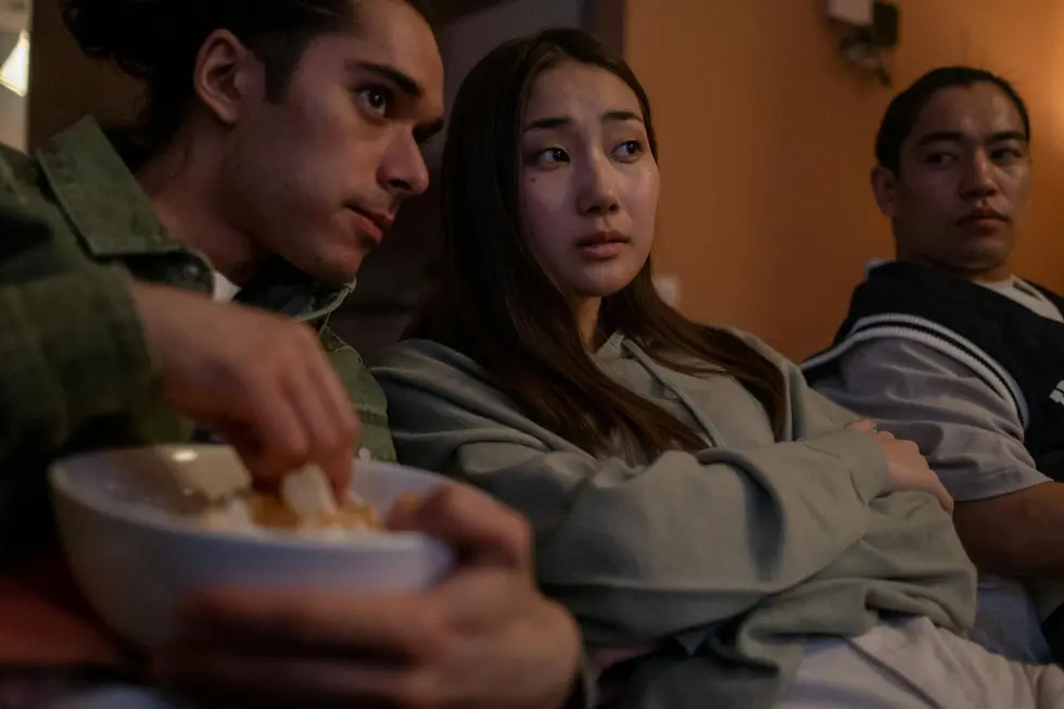 Jovens adultos curtindo filme de sequência em TV grande com som de qualidade